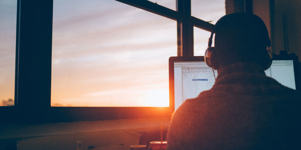 Person working on computer at sunset alone