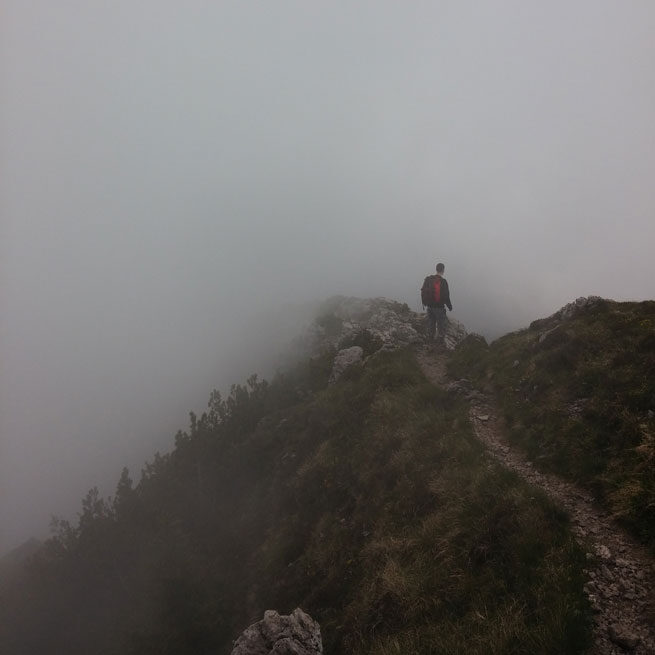 Person hiking into heavy fog