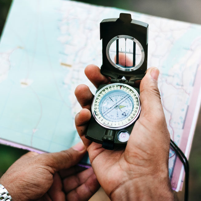 Person holding map and compass